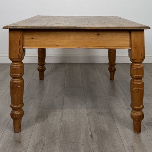 fig 2. A rectangular pine dining table with four turned legs, a planked top, and a single frieze drawer with a wooden knob.