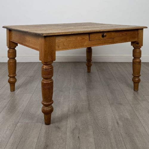 fig 6. A rectangular pine dining table with four turned legs, a planked top, and a single frieze drawer with a wooden knob.