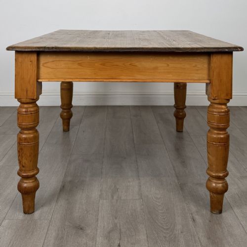 fig 7. A rectangular pine dining table with four turned legs, a planked top, and a single frieze drawer with a wooden knob.
