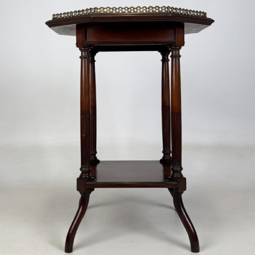 fig 2. An octagonal dark mahogany side table featuring a pierced brass gallery top, turned fluted columns, a lower tier shelf, and splayed legs.