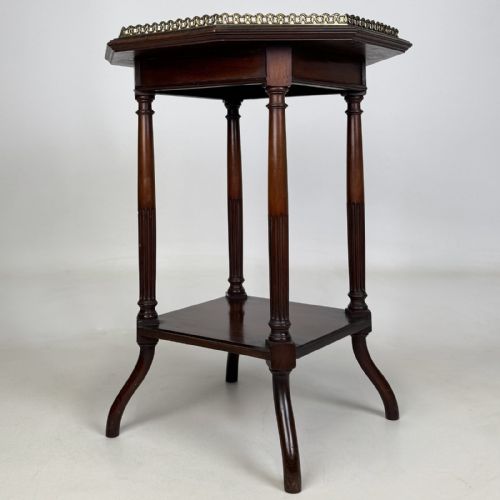 fig 3. An octagonal dark mahogany side table featuring a pierced brass gallery top, turned fluted columns, a lower tier shelf, and splayed legs.