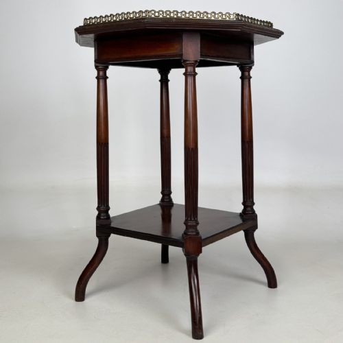 fig 5. An octagonal dark mahogany side table featuring a pierced brass gallery top, turned fluted columns, a lower tier shelf, and splayed legs.
