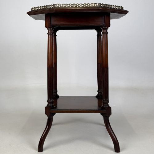 fig 6. An octagonal dark mahogany side table featuring a pierced brass gallery top, turned fluted columns, a lower tier shelf, and splayed legs.