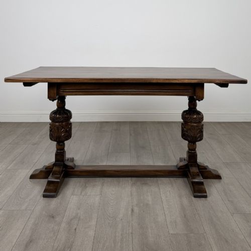fig 1. A dark oak refectory dining table featuring carved cup-and-cover legs joined by a floor-level stretcher.