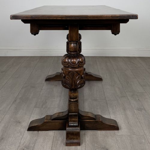 fig 2. A dark oak refectory dining table featuring carved cup-and-cover legs joined by a floor-level stretcher.