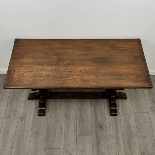 fig 3. A dark oak refectory dining table featuring carved cup-and-cover legs joined by a floor-level stretcher.