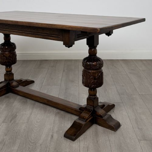 fig 4. A dark oak refectory dining table featuring carved cup-and-cover legs joined by a floor-level stretcher.