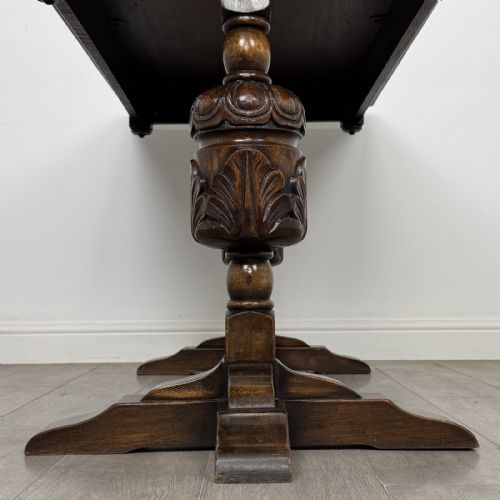 fig 5. A dark oak refectory dining table featuring carved cup-and-cover legs joined by a floor-level stretcher.