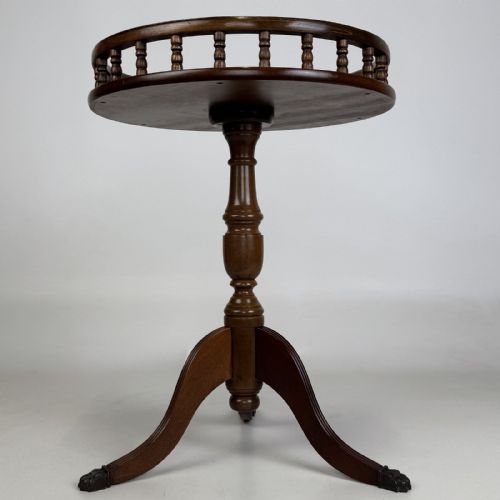 fig 2. A round dark beech tripod table featuring a turned central column, three splayed legs with claw feet, and a circular top framed by a raised spindle gallery.