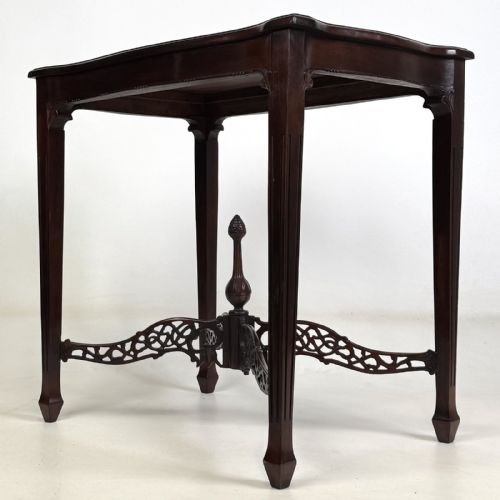 fig 1. An Edwardian mahogany side table with four square tapered legs, a carved fretwork X-stretcher, and a central turned finial.