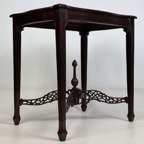 fig 3. An Edwardian mahogany side table with four square tapered legs, a carved fretwork X-stretcher, and a central turned finial.
