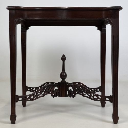 fig 4. An Edwardian mahogany side table with four square tapered legs, a carved fretwork X-stretcher, and a central turned finial.
