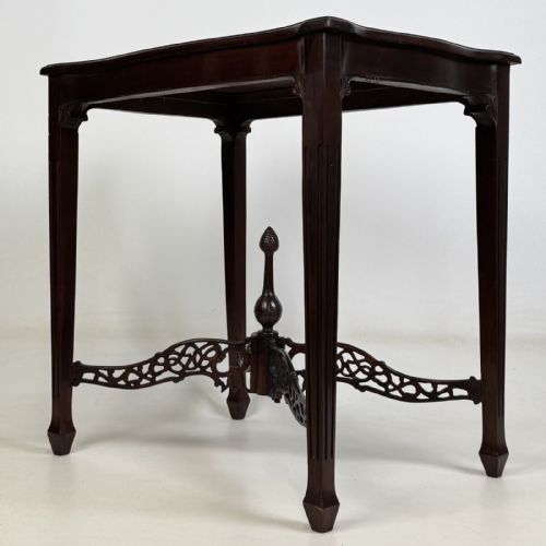 fig 5. An Edwardian mahogany side table with four square tapered legs, a carved fretwork X-stretcher, and a central turned finial.