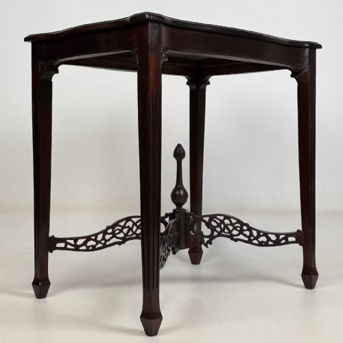 fig 7. An Edwardian mahogany side table with four square tapered legs, a carved fretwork X-stretcher, and a central turned finial.