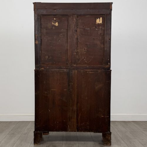 fig 4. An eighteenth-century Georgian mahogany glazed bookcase featuring an upper cabinet with glass doors and a lower cabinet with carved doors, lion mask handles, and Greek key frieze details.