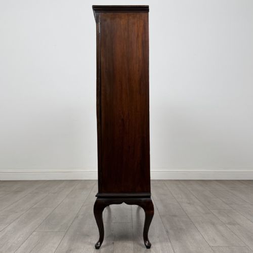 fig 2. An Edwardian dark mahogany display cabinet featuring twin astragal glazed doors and shaped cabriole legs.