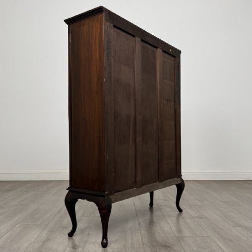 fig 3. An Edwardian dark mahogany display cabinet featuring twin astragal glazed doors and shaped cabriole legs.
