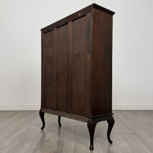 fig 5. An Edwardian dark mahogany display cabinet featuring twin astragal glazed doors and shaped cabriole legs.