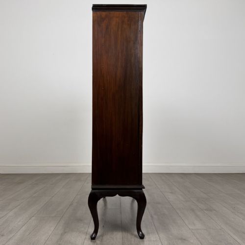 fig 6. An Edwardian dark mahogany display cabinet featuring twin astragal glazed doors and shaped cabriole legs.