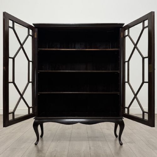 fig 8. An Edwardian dark mahogany display cabinet featuring twin astragal glazed doors and shaped cabriole legs.