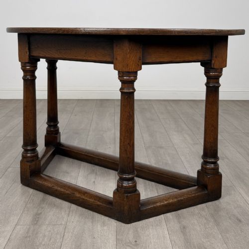 fig 1. A dark oak demi-lune side table featuring turned legs and a low perimeter stretcher base.