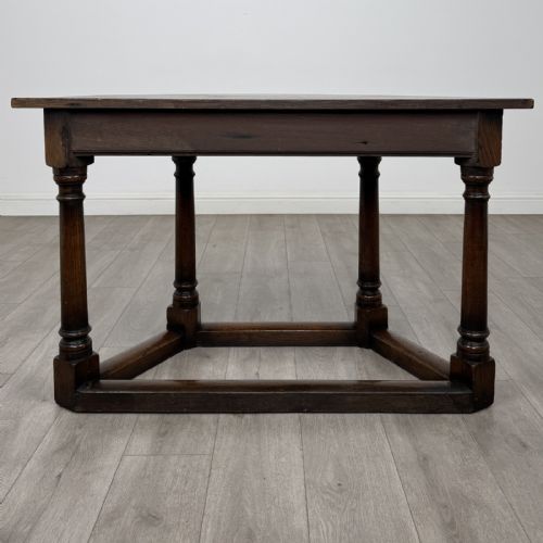 fig 3. A dark oak demi-lune side table featuring turned legs and a low perimeter stretcher base.