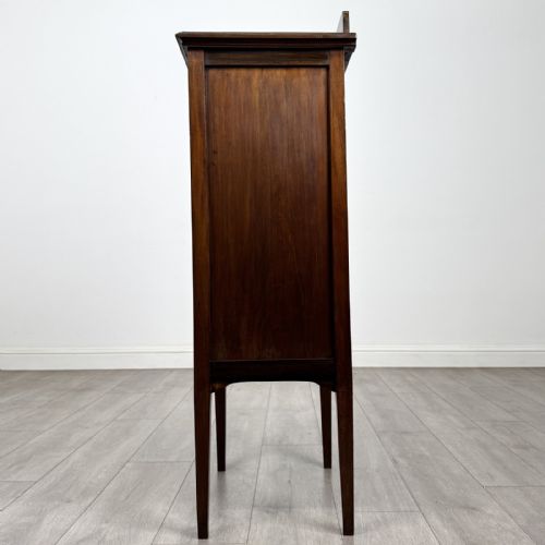 fig 2. A tall, narrow Edwardian mahogany cabinet featuring a top four-pane glazed compartment above four stacked drawers, resting on slim tapered legs.