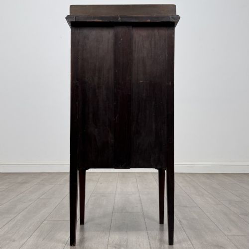 fig 4. A tall, narrow Edwardian mahogany cabinet featuring a top four-pane glazed compartment above four stacked drawers, resting on slim tapered legs.