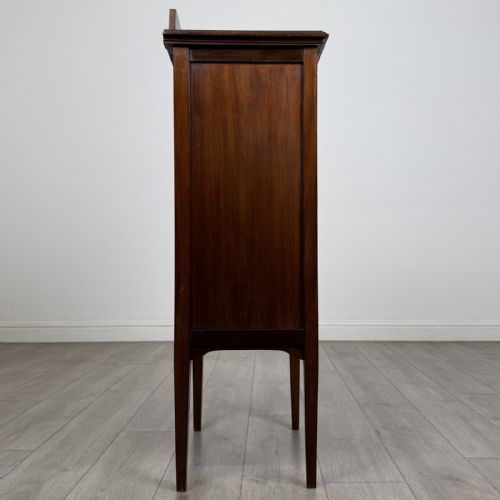 fig 6. A tall, narrow Edwardian mahogany cabinet featuring a top four-pane glazed compartment above four stacked drawers, resting on slim tapered legs.