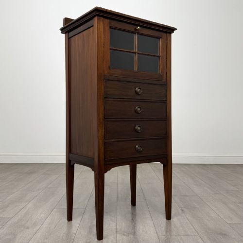fig 7. A tall, narrow Edwardian mahogany cabinet featuring a top four-pane glazed compartment above four stacked drawers, resting on slim tapered legs.