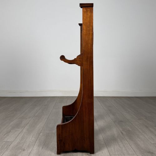 fig 2. An Edwardian walnut hall stand featuring central fluted wood paneling, two metal hanging hooks, a stick retention bar, and a lower drip tray.