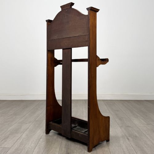 fig 5. An Edwardian walnut hall stand featuring central fluted wood paneling, two metal hanging hooks, a stick retention bar, and a lower drip tray.