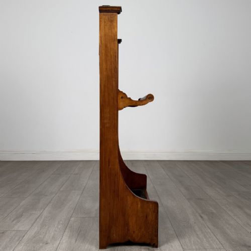 fig 6. An Edwardian walnut hall stand featuring central fluted wood paneling, two metal hanging hooks, a stick retention bar, and a lower drip tray.