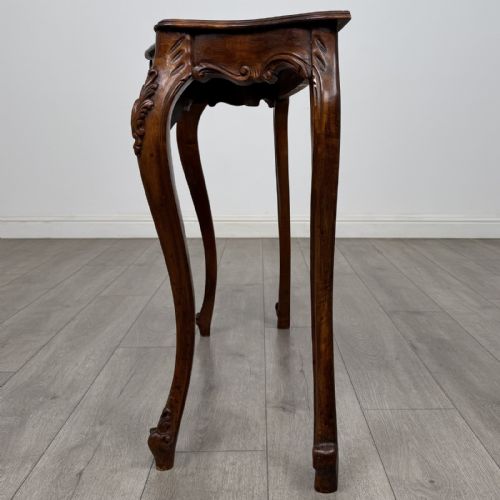 fig 2. A carved mahogany French style side table featuring exaggerated cabriole legs, a shell motif apron, and a serpentine tabletop.