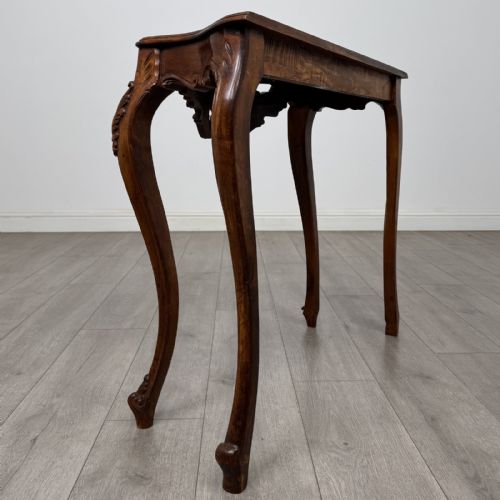 fig 3. A carved mahogany French style side table featuring exaggerated cabriole legs, a shell motif apron, and a serpentine tabletop.