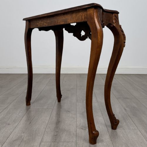 fig 5. A carved mahogany French style side table featuring exaggerated cabriole legs, a shell motif apron, and a serpentine tabletop.