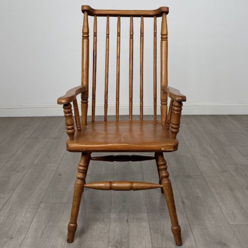 fig 7. A pitch pine stick back armchair featuring vertical spindle uprights, turned legs, shaped armrests, and turned stretchers.