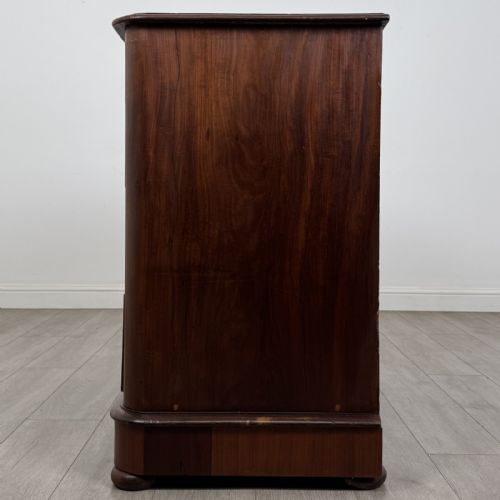 fig 2. An antique Victorian mahogany chest of drawers featuring two short drawers above three long graduated drawers with turned knobs and bun feet.