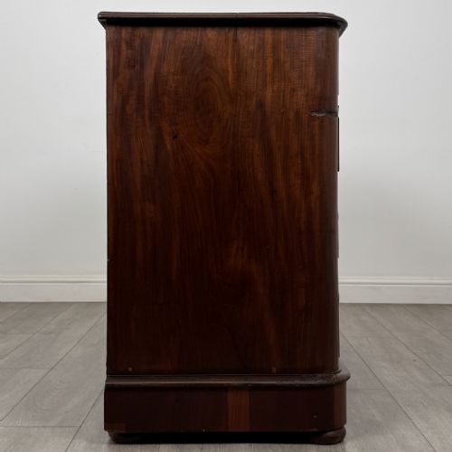 fig 6. An antique Victorian mahogany chest of drawers featuring two short drawers above three long graduated drawers with turned knobs and bun feet.