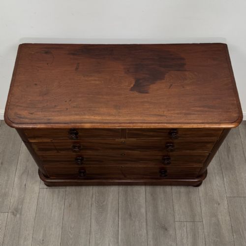fig 8. An antique Victorian mahogany chest of drawers featuring two short drawers above three long graduated drawers with turned knobs and bun feet.