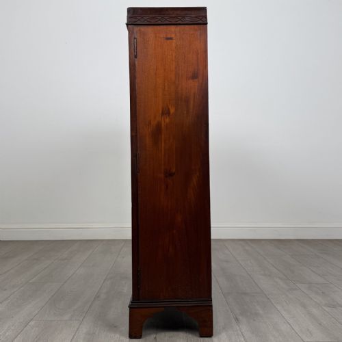 fig 2. An Edwardian dark mahogany display cabinet featuring twin astragal glazed doors with Gothic tracery and bracket feet.