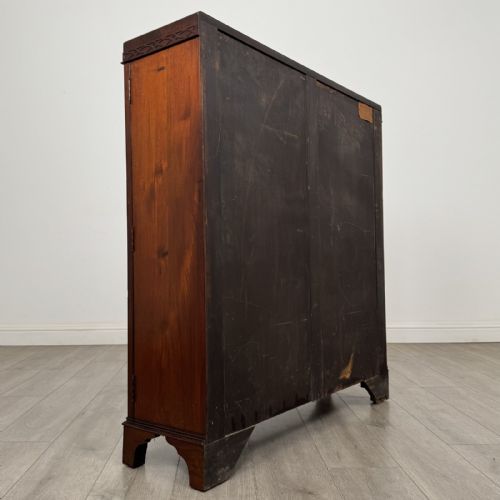 fig 3. An Edwardian dark mahogany display cabinet featuring twin astragal glazed doors with Gothic tracery and bracket feet.