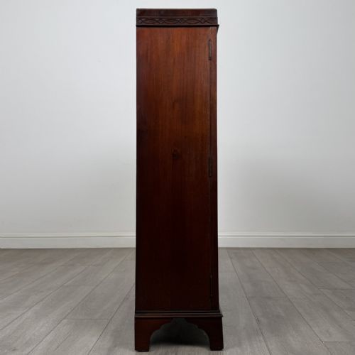fig 6. An Edwardian dark mahogany display cabinet featuring twin astragal glazed doors with Gothic tracery and bracket feet.