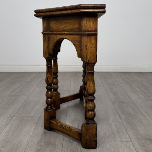 fig 2. An early 20th-century golden oak fold-over tea table featuring an octagonal top, arched frieze with a single central drawer, turned legs, and lower stretchers.