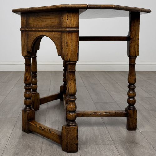 fig 3. An early 20th-century golden oak fold-over tea table featuring an octagonal top, arched frieze with a single central drawer, turned legs, and lower stretchers.