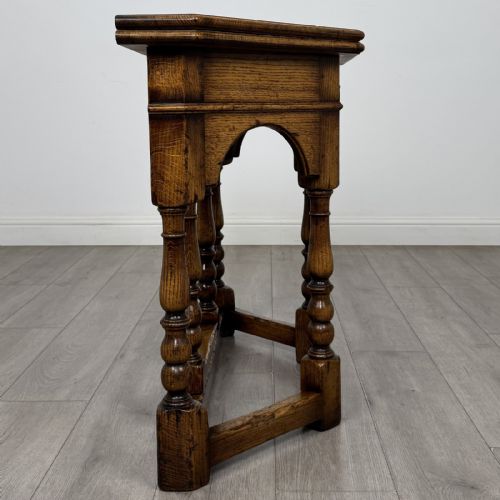 fig 5. An early 20th-century golden oak fold-over tea table featuring an octagonal top, arched frieze with a single central drawer, turned legs, and lower stretchers.