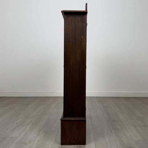 fig 2. An antique dark oak open bookcase featuring four horizontal shelves, a low raised top gallery, and shaped bracket feet.