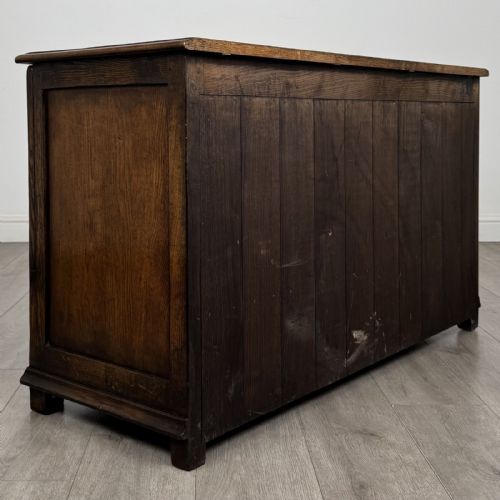 fig 3. A dark oak Georgian style drop-front mule chest featuring three arched fielded panels and two lower drawers with brass swan-neck handles.
