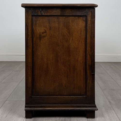 fig 6. A dark oak Georgian style drop-front mule chest featuring three arched fielded panels and two lower drawers with brass swan-neck handles.