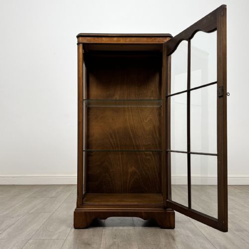 fig 1. A standing burr walnut display cabinet with a single six-pane glass door and a bracket foot base.